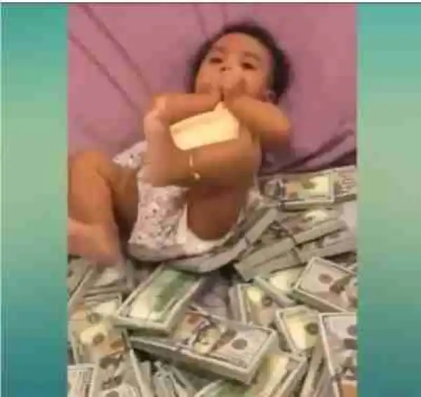 Nigerian Man Drops Bundles Of 100 Dollar Bills For His Child To Play With (Photos)